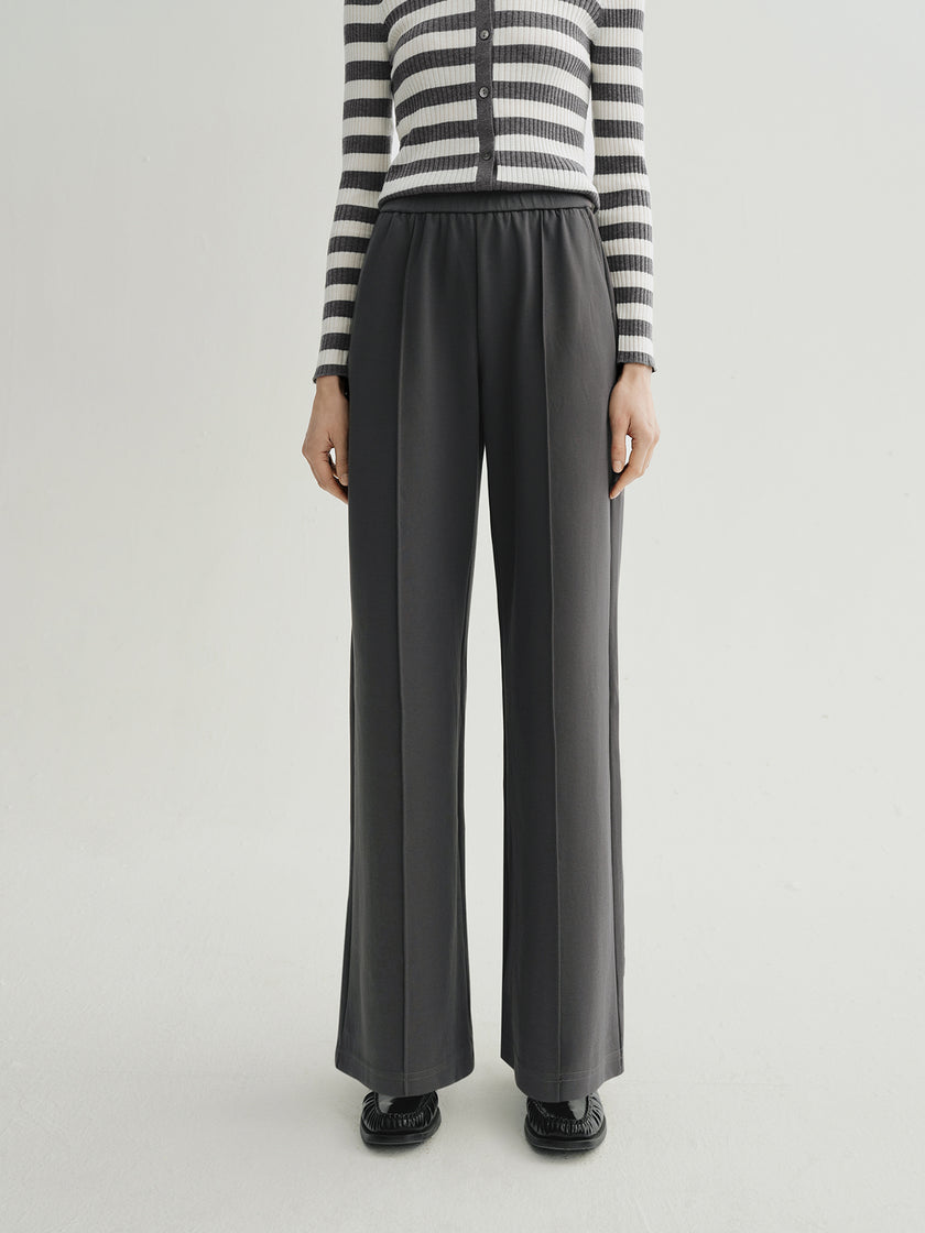 Person wearing black wide-leg pants with a striped sweater on a white background