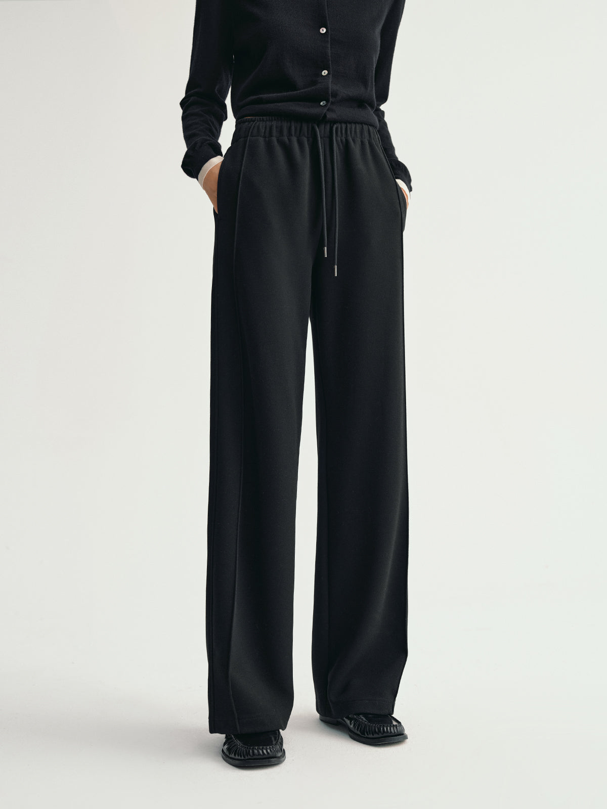 Black pants worn by a person on a white background