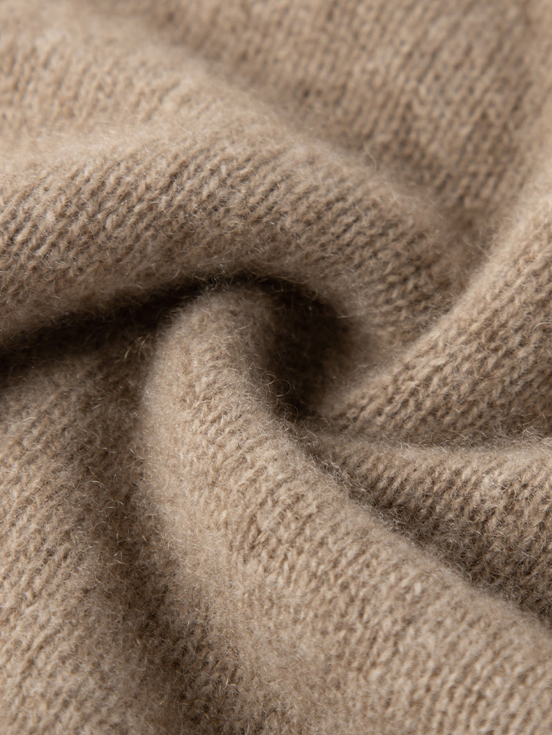 Close-up of a soft camel cashmere sweater fabric showcasing its luxurious texture.