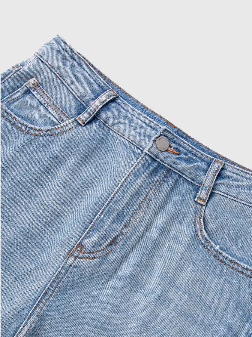 Close-up of a blue denim jeans pocket with brand logo on a light gray background