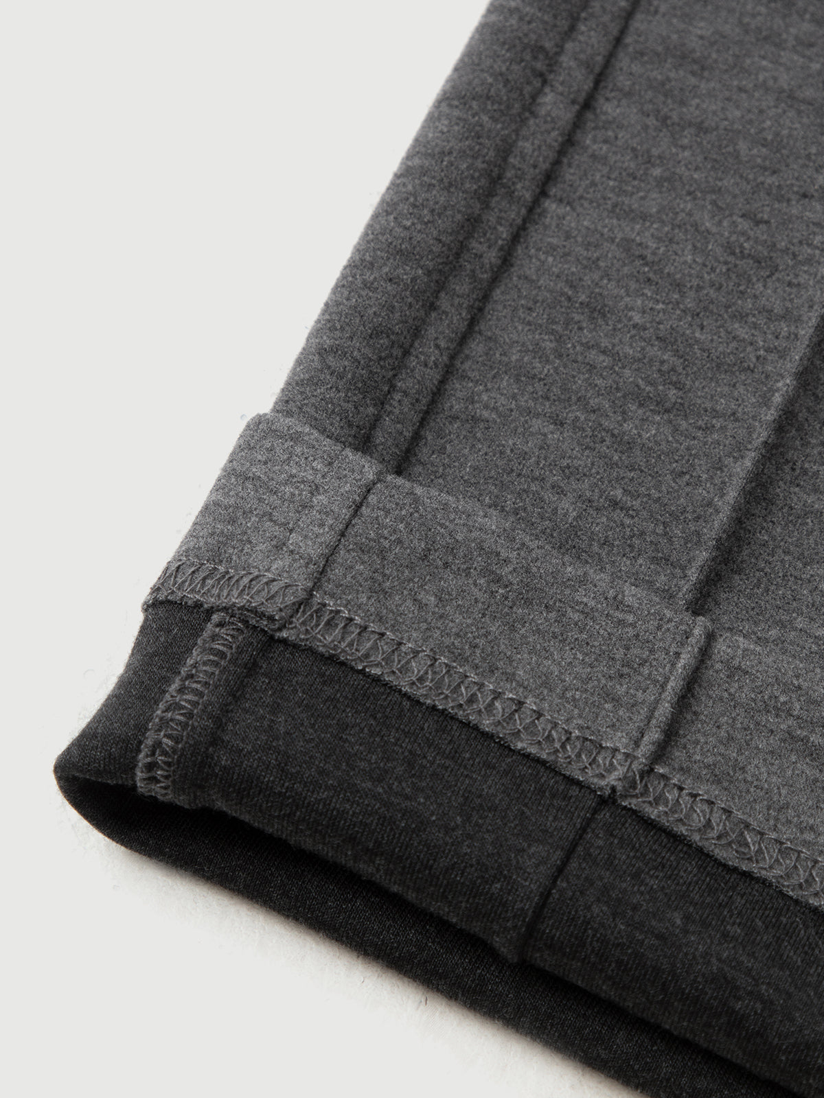 Close-up of gray sweatpants with a white background