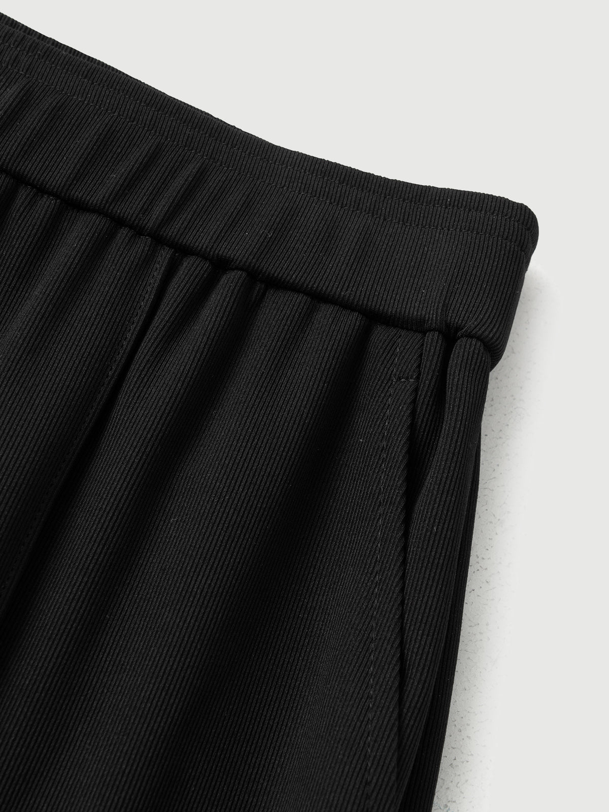 Close-up of black pants on a light gray background