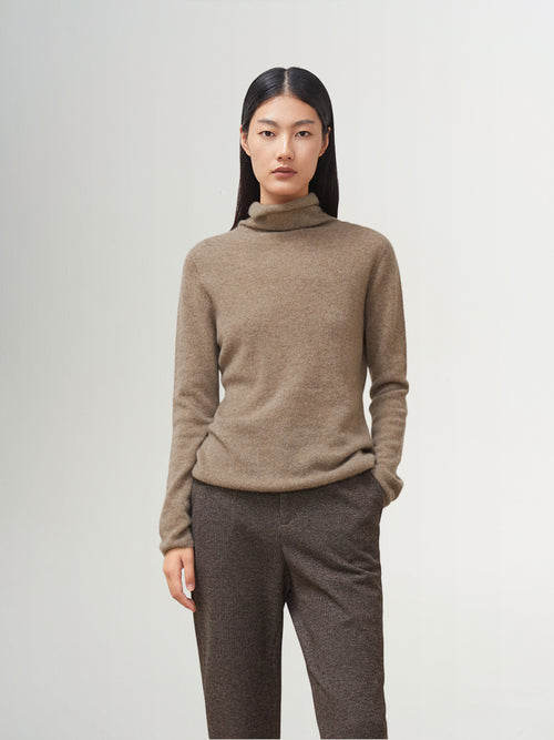 Load image 1 in gallery view. A woman wearing a women's premium brown turtleneck cashmere sweater with a classic fit, showcasing a luxurious and cozy look