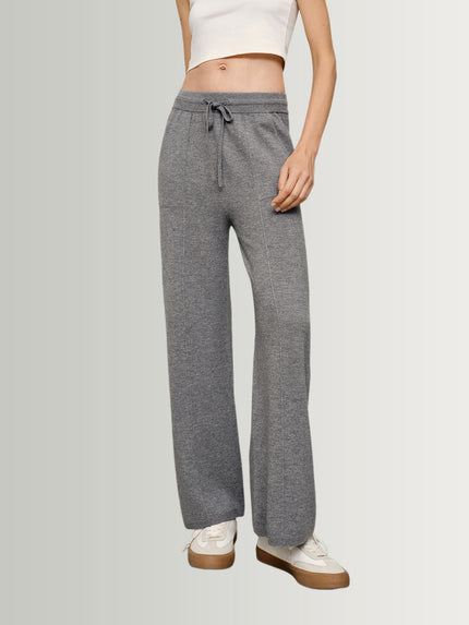 Person wearing gray drawstring pants on a plain background