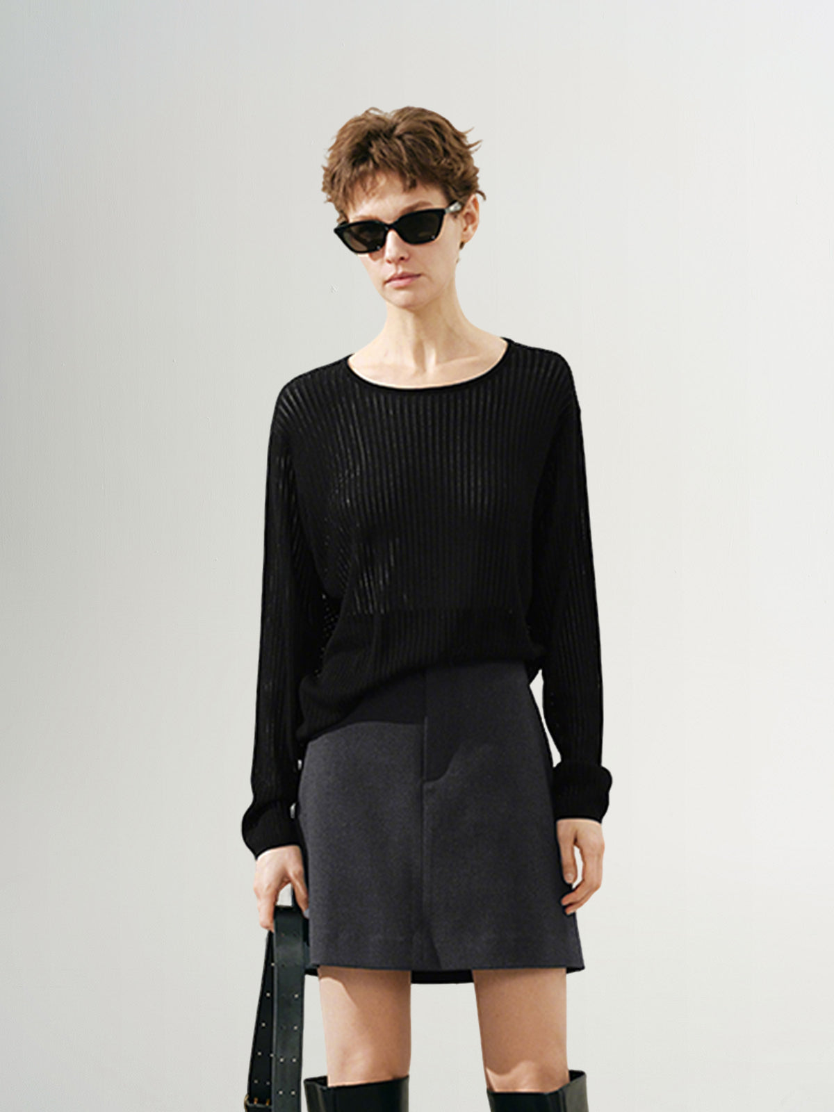 A woman wearing a women's crew neck long sleeve sweater in a classic fit, offering a cozy and versatile look for everyday wear.