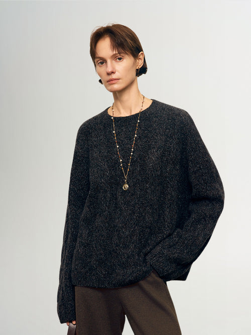 Load image 1 in gallery view. Person wearing a dark sweater and brown pants against a plain background