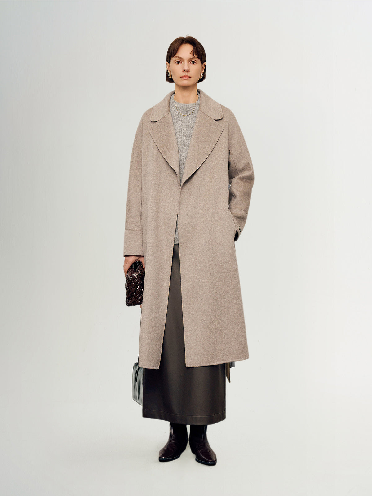 Person wearing a beige coat on a white background