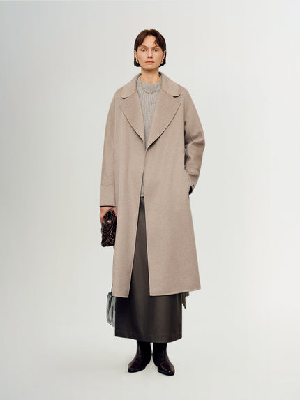 Person wearing a beige coat on a white background