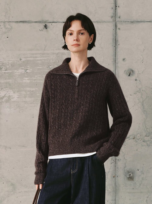 Load image 1 in gallery view. Person wearing a brown knitted sweater against a concrete wall