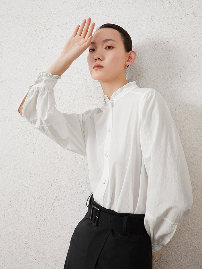 A woman wearing a women's stand collar long sleeve blouse in a crisp, elegant design with trim details, paired with midi skirt for a chic and polished look.