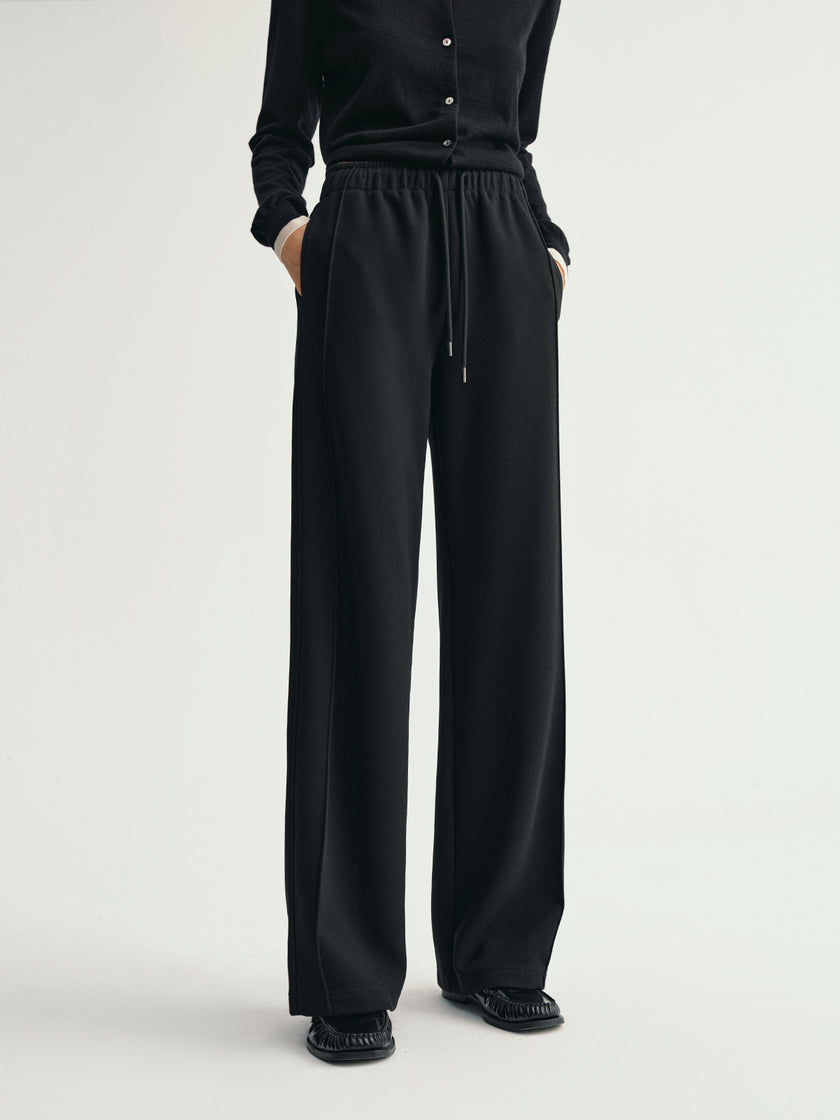 Black pants worn by a person on a white background