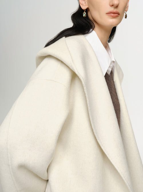 Load image 1 in gallery view. Person wearing a cream-colored coat with a plain background