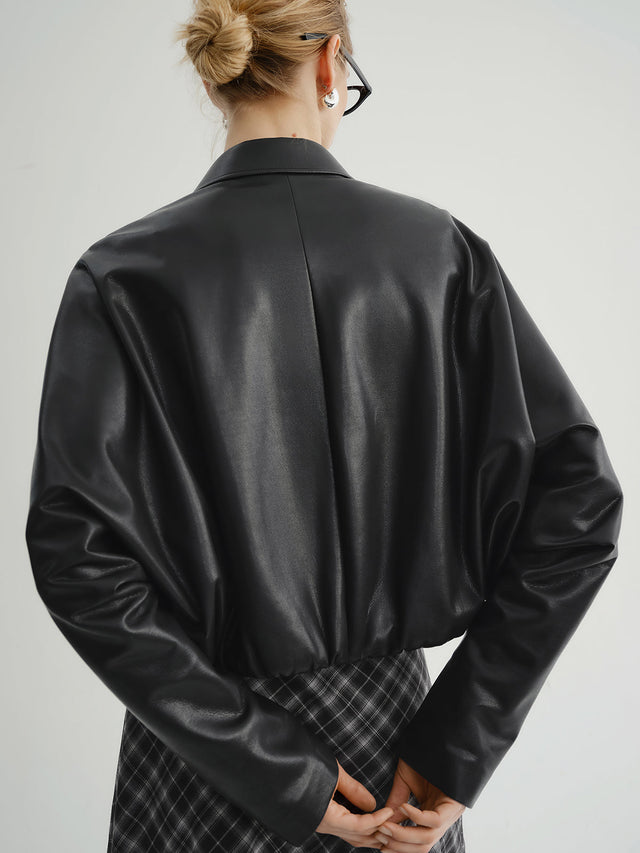 Model wearing a black leather jacket show the back of the outfit