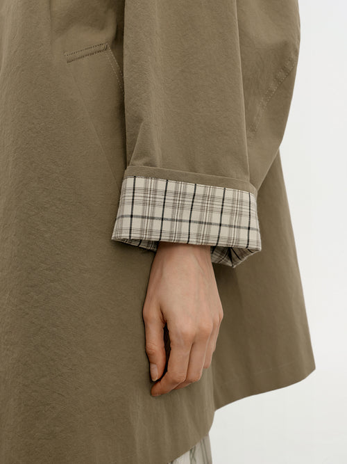 Load image 1 in gallery view. Close-up of model wearing a green coat with plaid cuffs on a white background