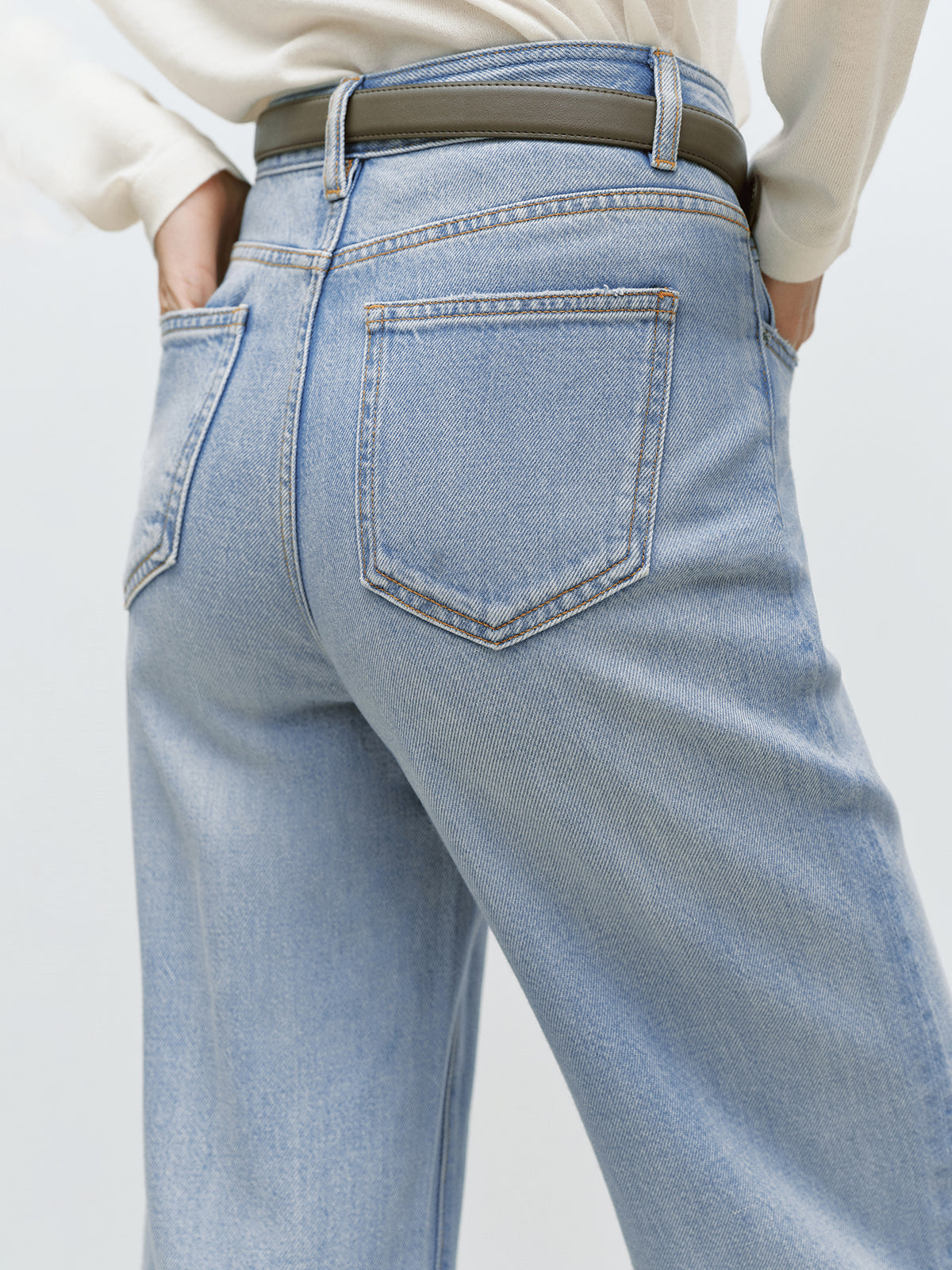 Light blue jeans worn by a person on a plain background
