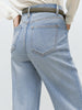 Light blue jeans worn by a person on a plain background