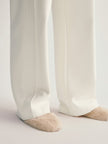 White pants worn by a person on a light gray background