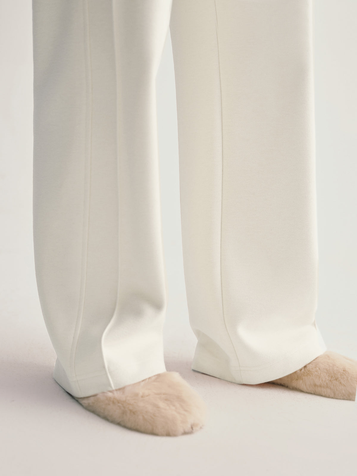 White pants worn by a person on a light gray background