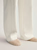 White pants worn by a person on a light gray background