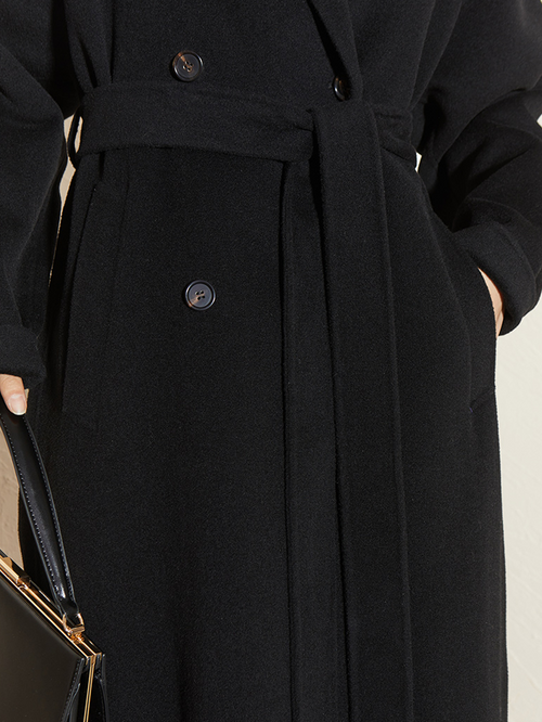 Load image 1 in gallery view. Close-up of a black coat with buttons on a neutral background
