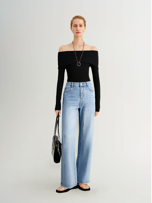 Load image 1 in gallery view. Woman wearing a black off-shoulder top and light blue jeans on a white background