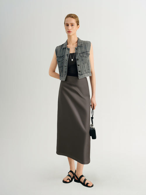 Load image 1 in gallery view. Woman wearing a denim vest, black top, and long dark skirt on a white background