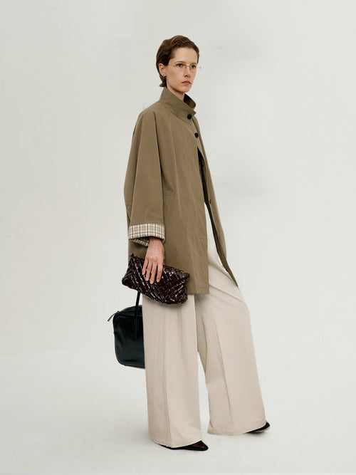 Load image 1 in gallery view. Model wearing a beige coat and holding a black handbag on a white background