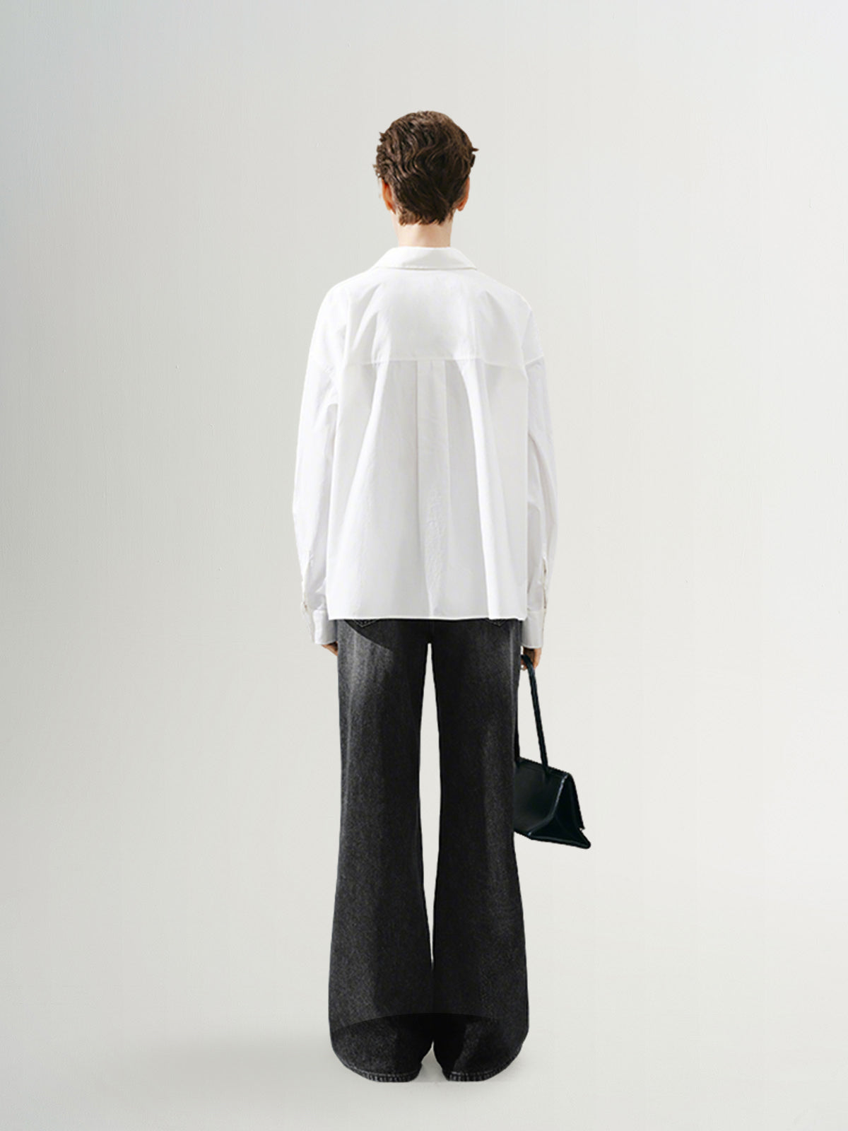 Back view of a model wearing a pure cotton shirt with oversized fit and stylish pants.