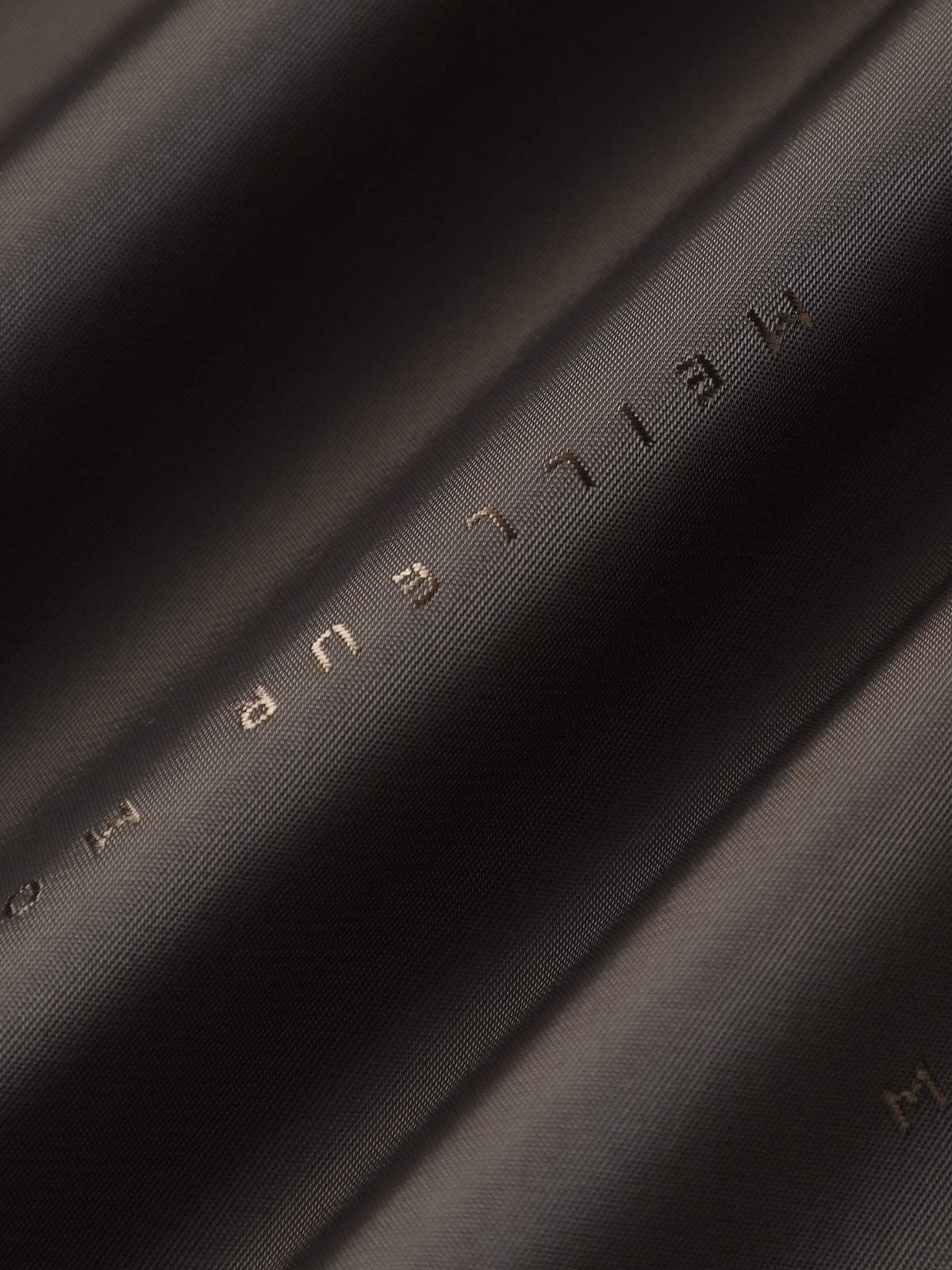Close-up of black fabric with 'MEILEN' branding.