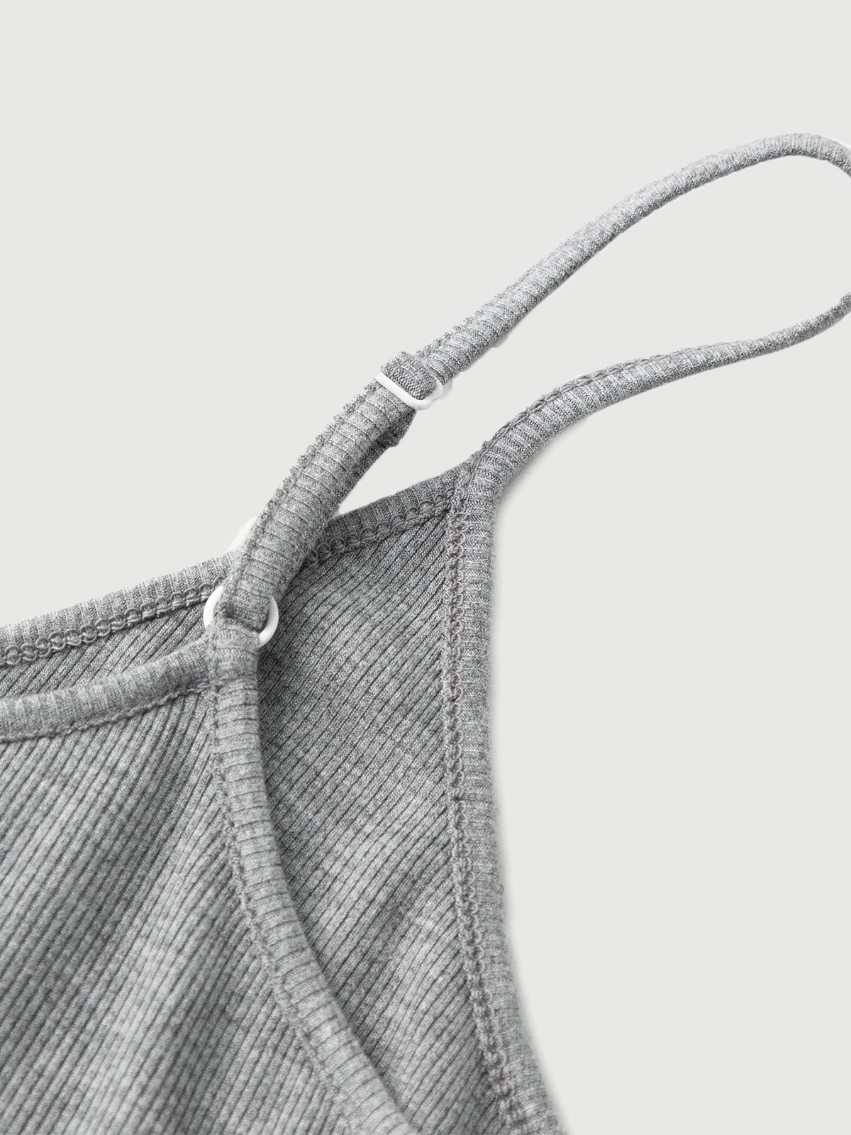 Close-up of a textured gray fabric with a strap on a light gray background