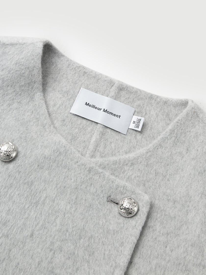 Gray garment with silver buttons and a visible brand label on a light gray background