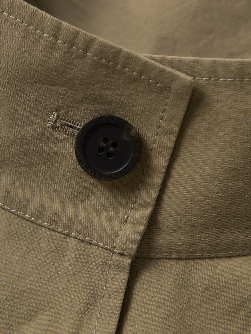Load image 1 in gallery view. Close-up of a button on a beige fabric with a brand logo.