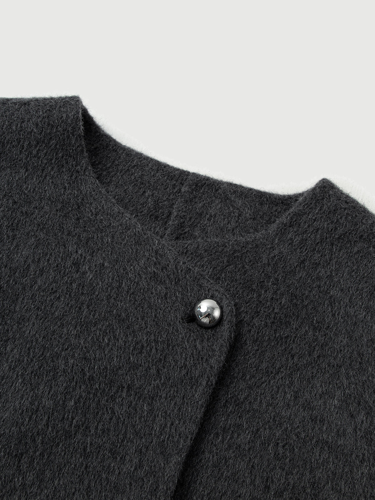 Close-up of a dark gray textured garment with a button