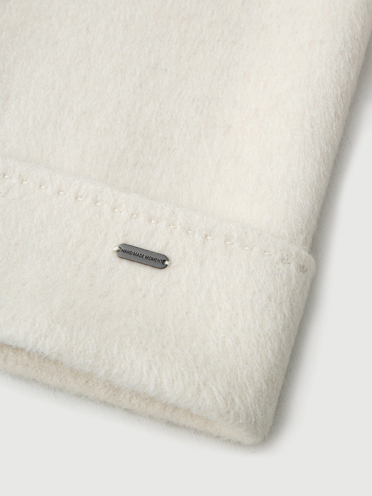 Close-up of a textured fabric with a brand label on a white background