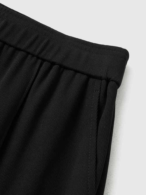 Load image 1 in gallery view. Close-up of black pants on a light gray background