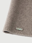 Close-up of a gray fabric with a brand label on a light gray background