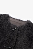 Close-up of a dark gray fleece jacket with buttons on a light gray background