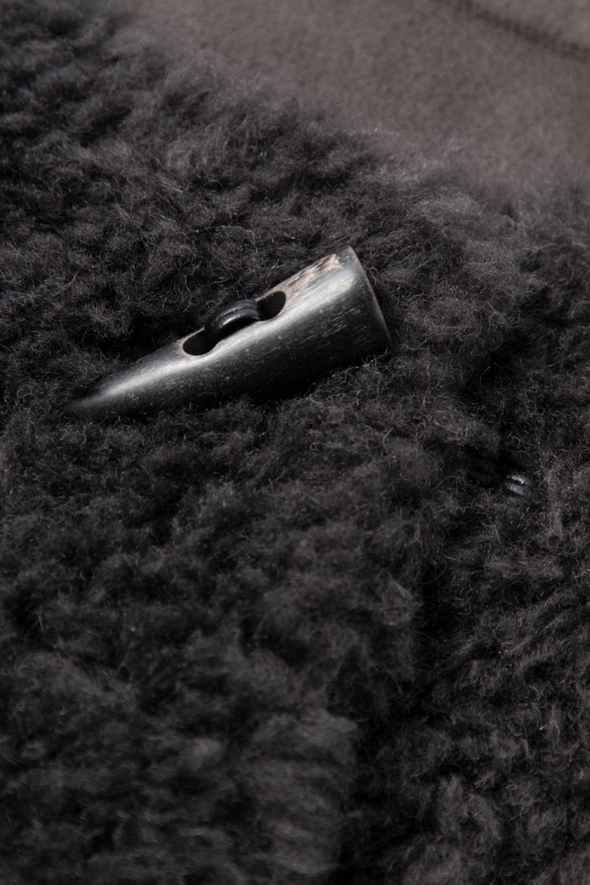 Close-up of a button on a dark textured fabric