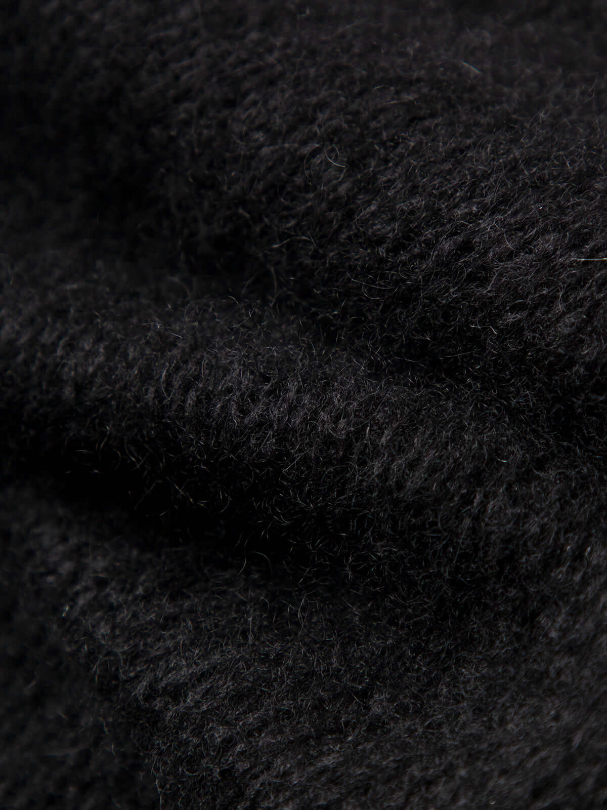 Close-up texture of Cashmere-Silk Relaxed Pullover Sweater showing soft black fabric detail.