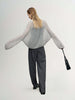 Cashmere-Silk Relaxed Pullover Sweater showcased on a model wearing gray trousers and carrying a black bag.