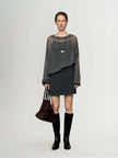 Cashmere-Silk Relaxed Pullover Sweater styled with a short gray skirt and knee-high boots.