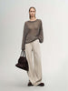 Model wearing a Cashmere-Silk Relaxed Pullover Sweater with beige trousers and holding a handbag.