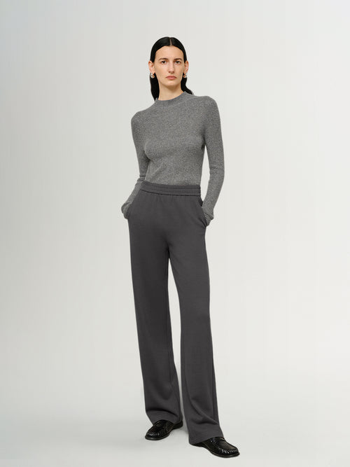 Load image 1 in gallery view. Person wearing a gray sweater and pants on a white background