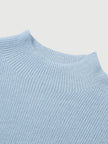 Close-up of a light blue ribbed sweater on a light gray background