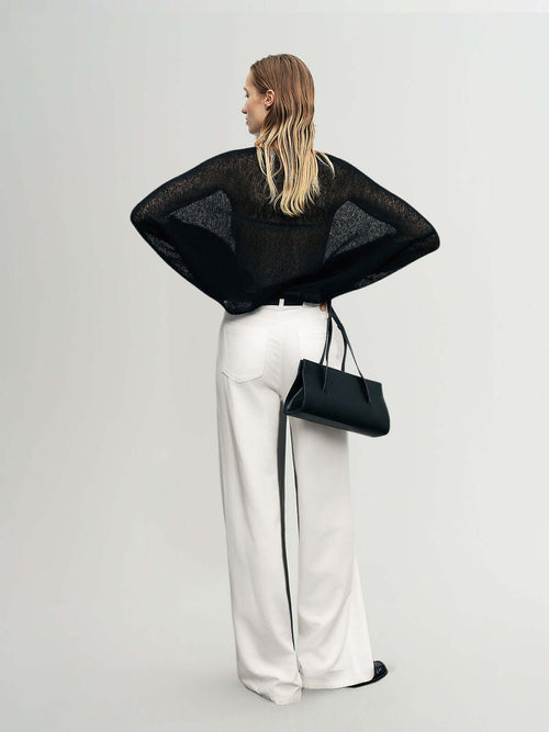Load image 1 in gallery view. Cashmere-Silk Relaxed Pullover Sweater showcased with wide white trousers and a black handbag.