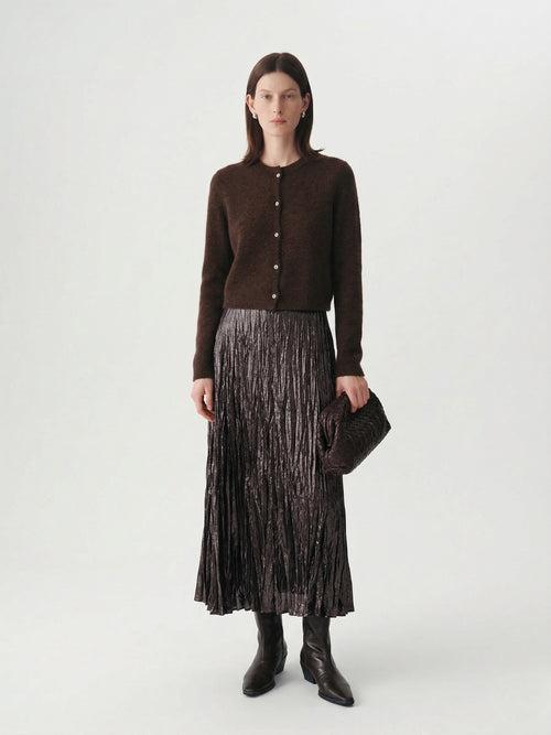 Load image 1 in gallery view. Silk-Cashmere Cardigan worn with a pleated skirt, showcasing its soft texture and versatile style.