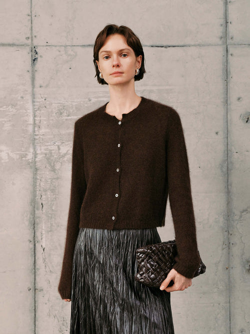 Load image 1 in gallery view. Silk-Cashmere Cardigan worn with a pleated skirt, showcasing its soft texture and versatile style.