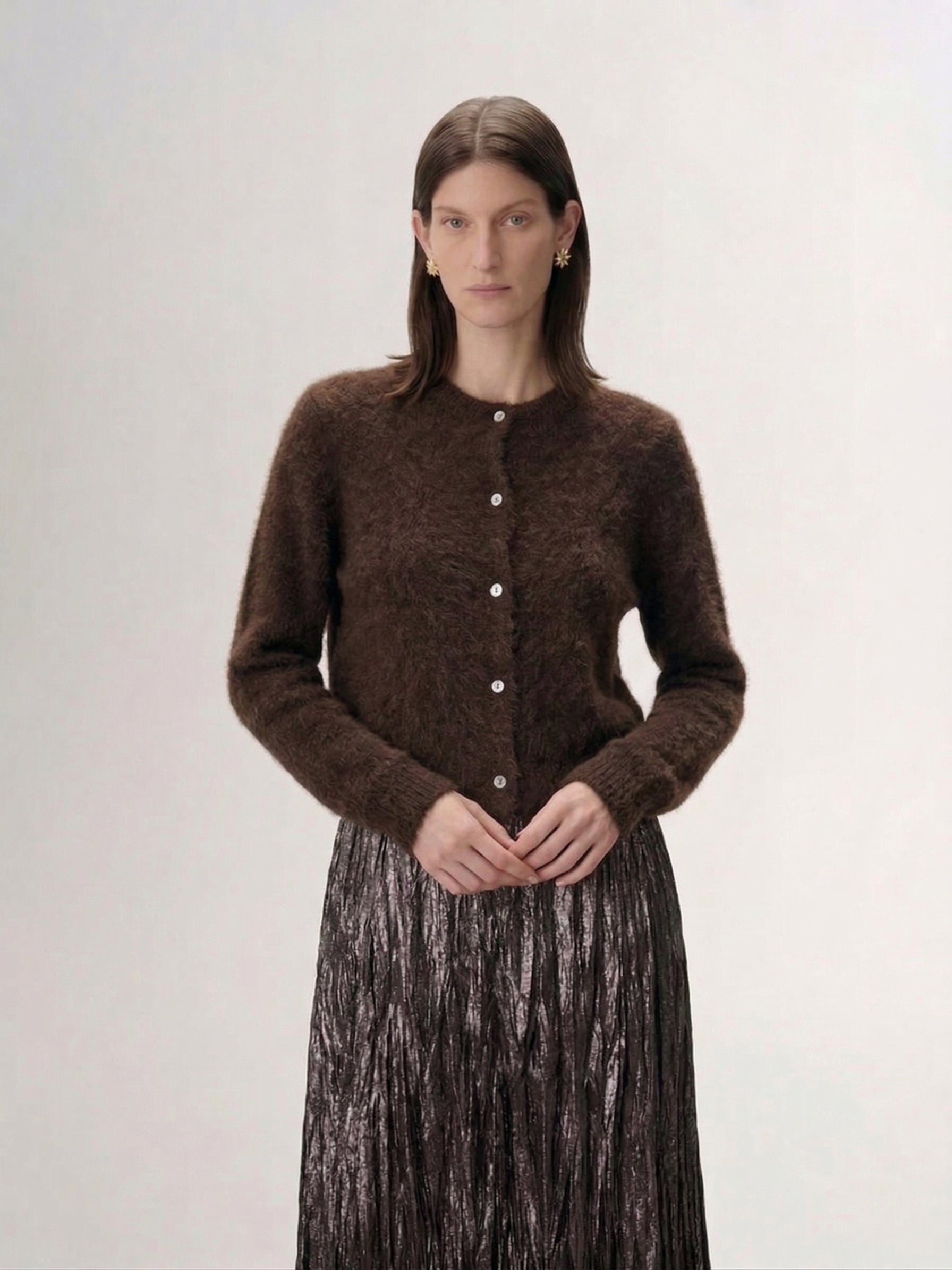 Silk-Cashmere Cardigan worn by a model, featuring a soft brown hue and button closure against a textured backdrop.