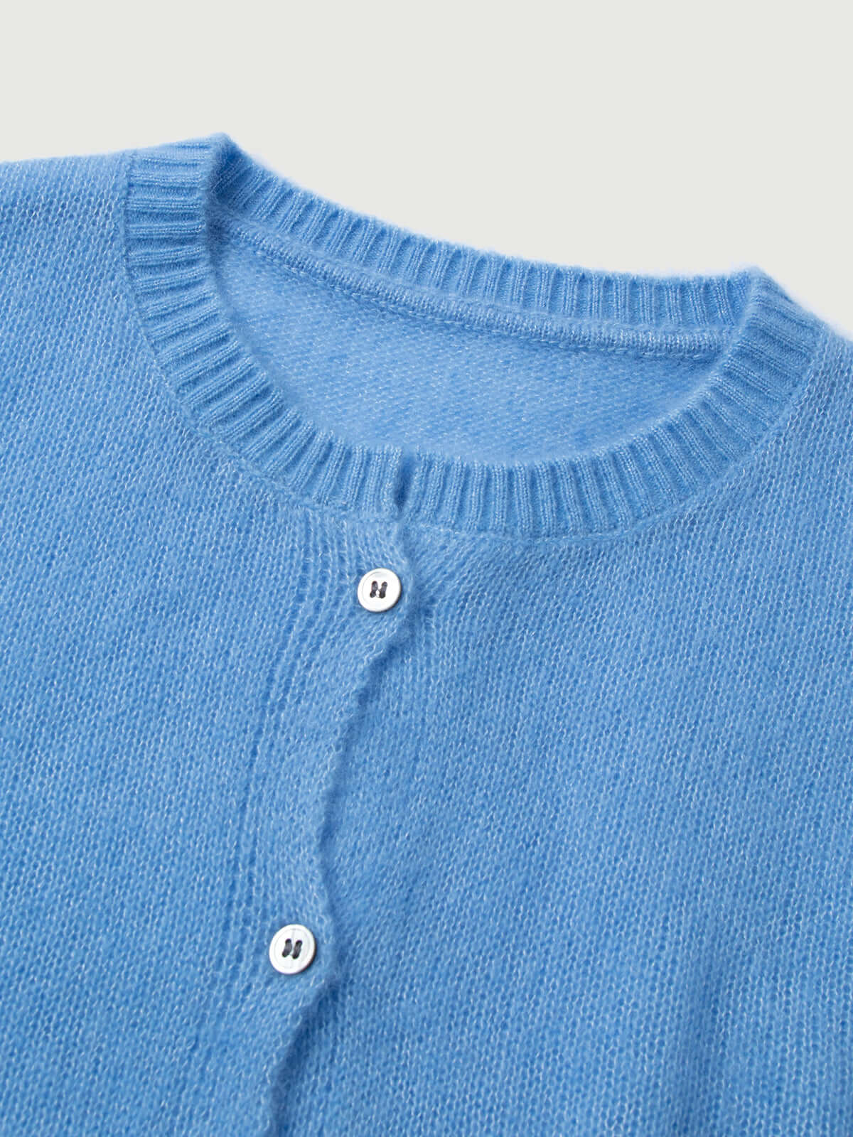 Silk-Cashmere Cardigan in light blue, showcasing soft texture and button details, perfect for layering.