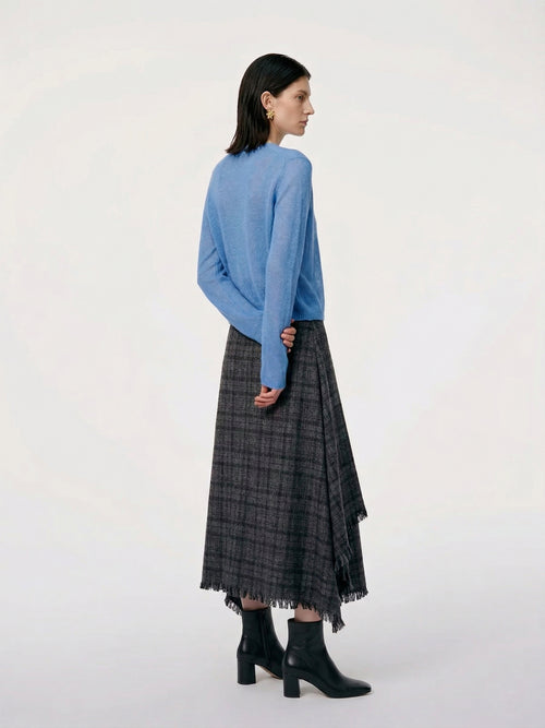 Load image 1 in gallery view. Model wearing a Silk-Cashmere Cardigan in soft blue, paired with a black plaid skirt and stylish accessories.